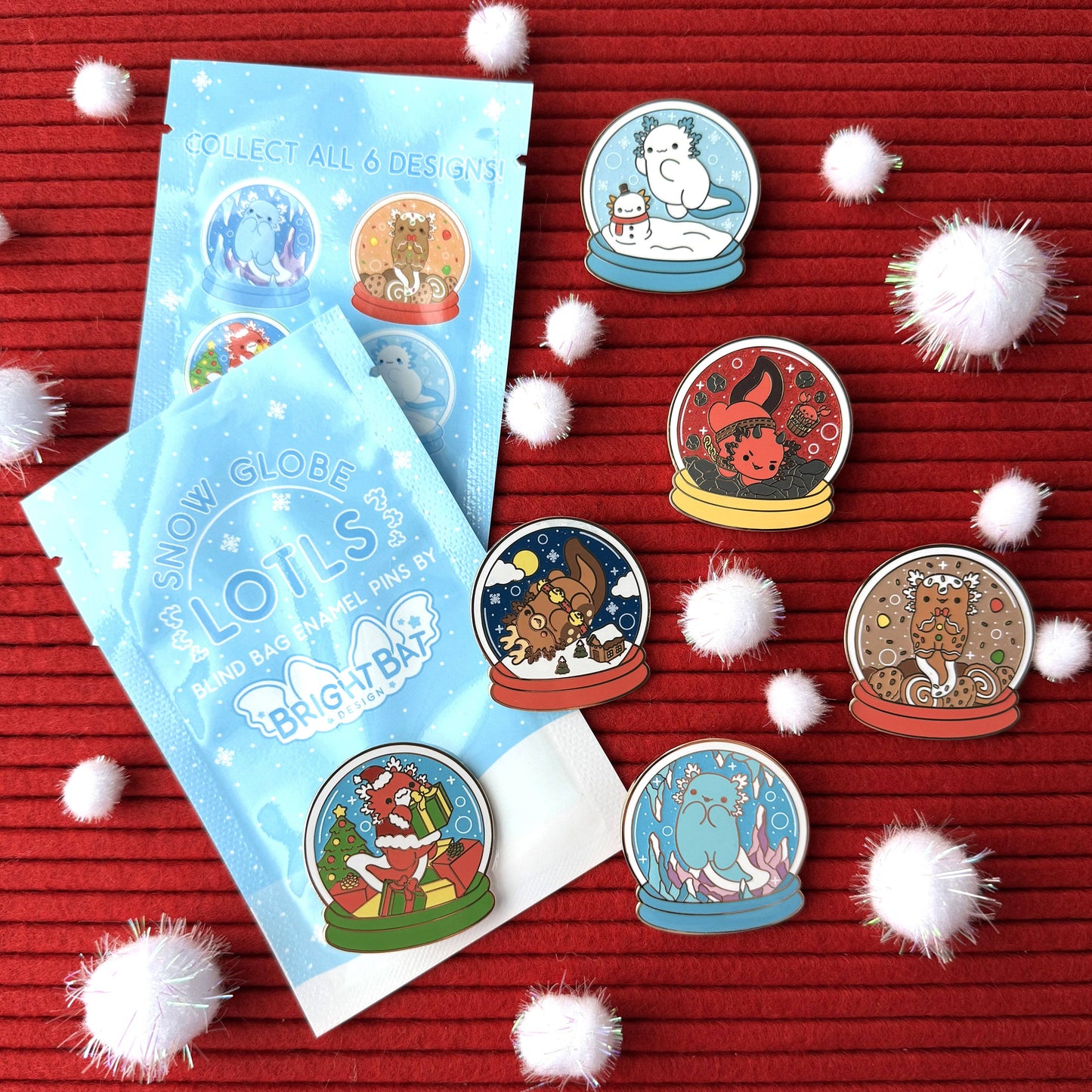 Snow globe-themed collectible pins with packaging on a red background